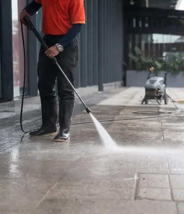 tsunami pressure washing hoover al Professional pressure washing technician cleaning a commercial sidewalk with high-pressure water in Hoover, Alabama.